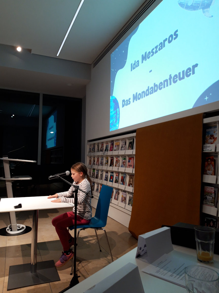 Ida Meszaros liest  einen  Auszug  ihrer Geschichte „ Das Mondabenteuer“ vor. Sie gewinnt den dritten Platz des Jurypreises.